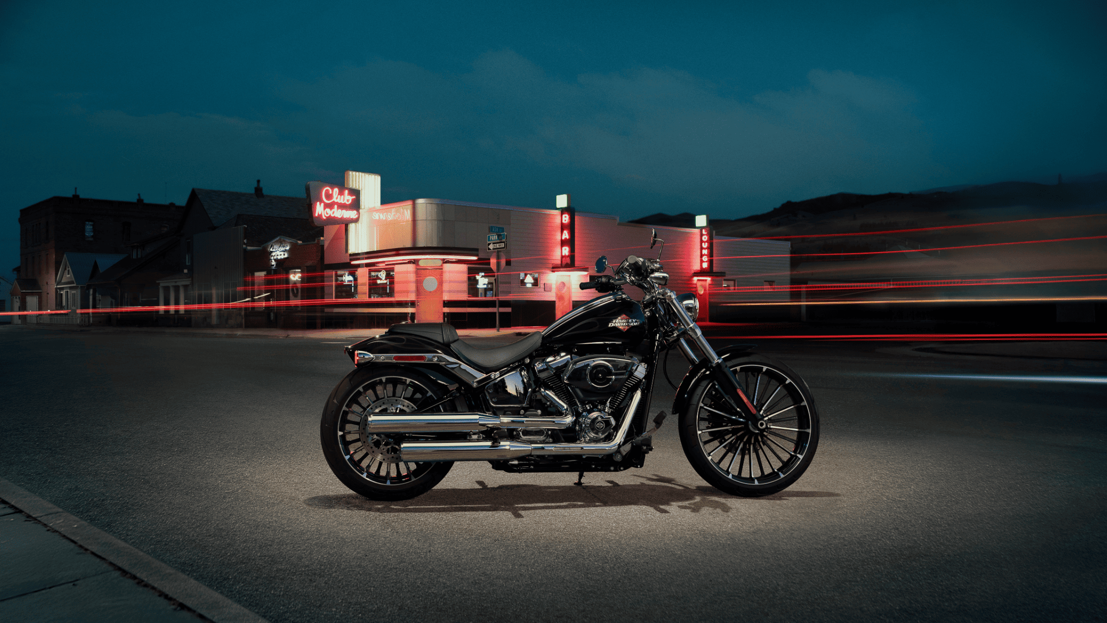 2025 H-D® Breakout® in black parked near neon-lit nightlife backdrop with glowing city lights
