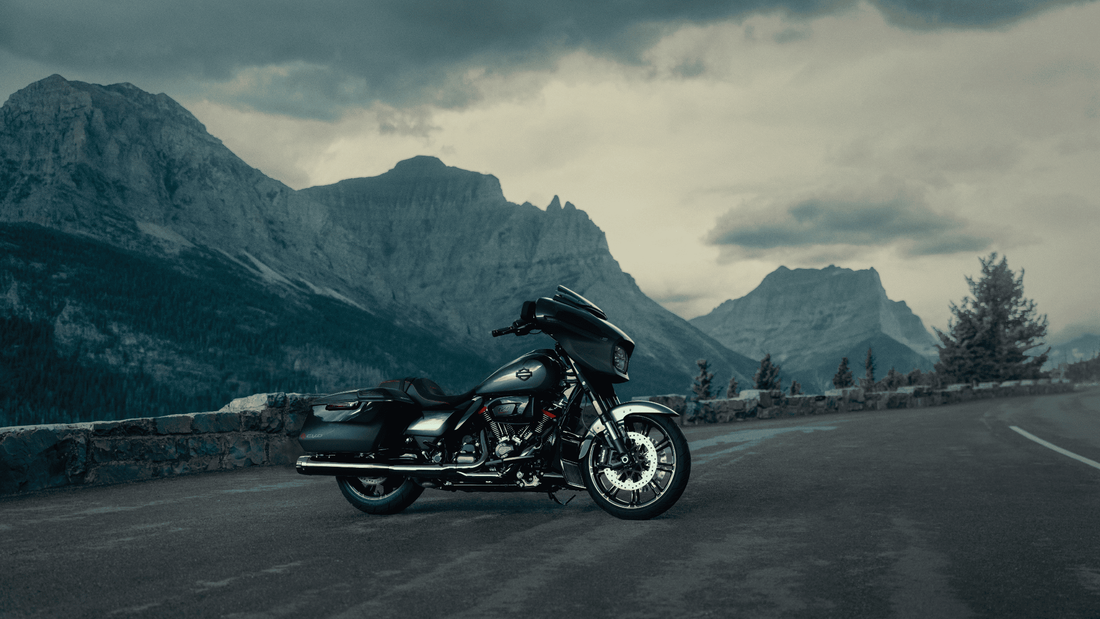 2025 Harley-Davidson CVO Street Glide on mountain road, luxury black touring motorcycle