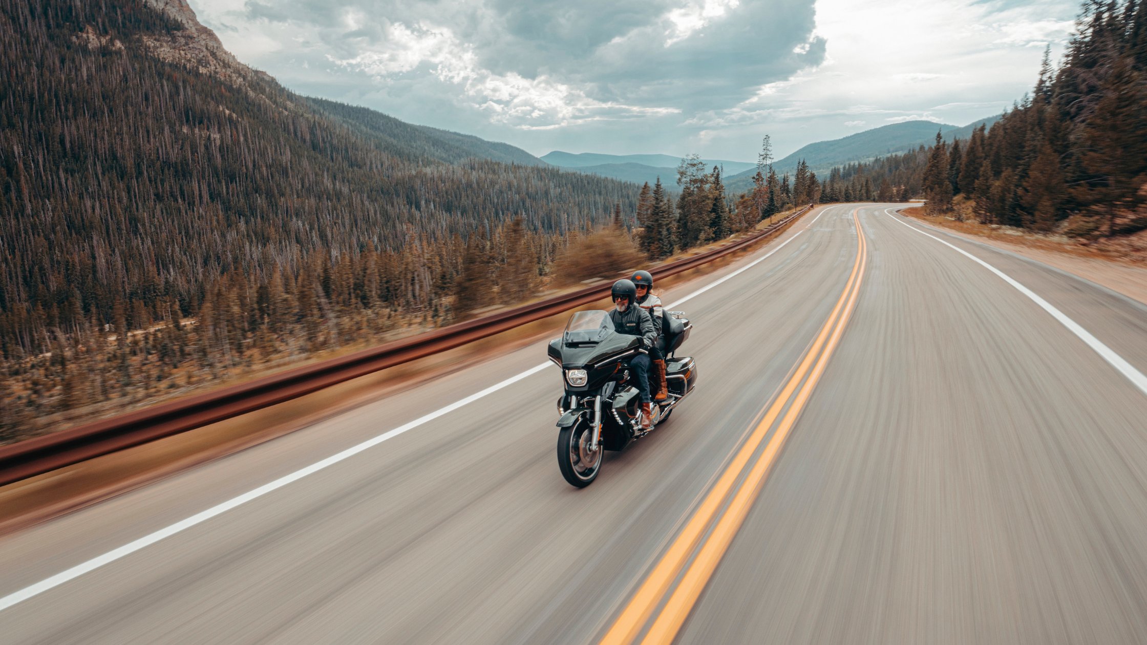 Two riders cruising a 2026 Harley-Davidson® Street Glide® Limited on scenic mountain highway